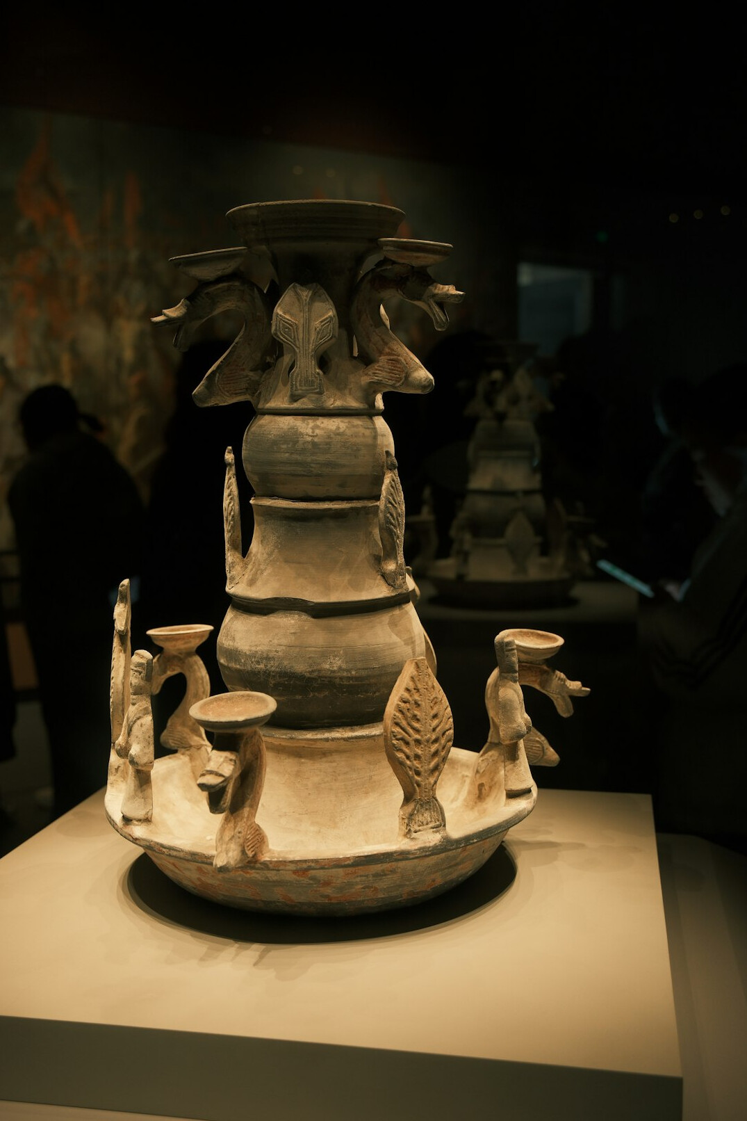 Ornate antique vase displayed on a museum pedestal